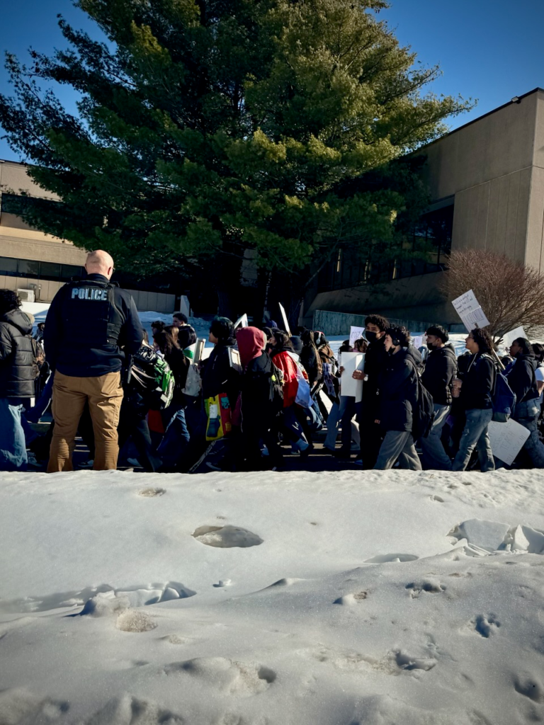 Edison High School students march past a police officer during a peaceful anti-ICE protest escorted by police