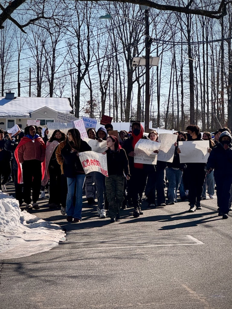 A large group of Edison High School students hold signs while marching against ICE enforcement in Edison, New Jersey